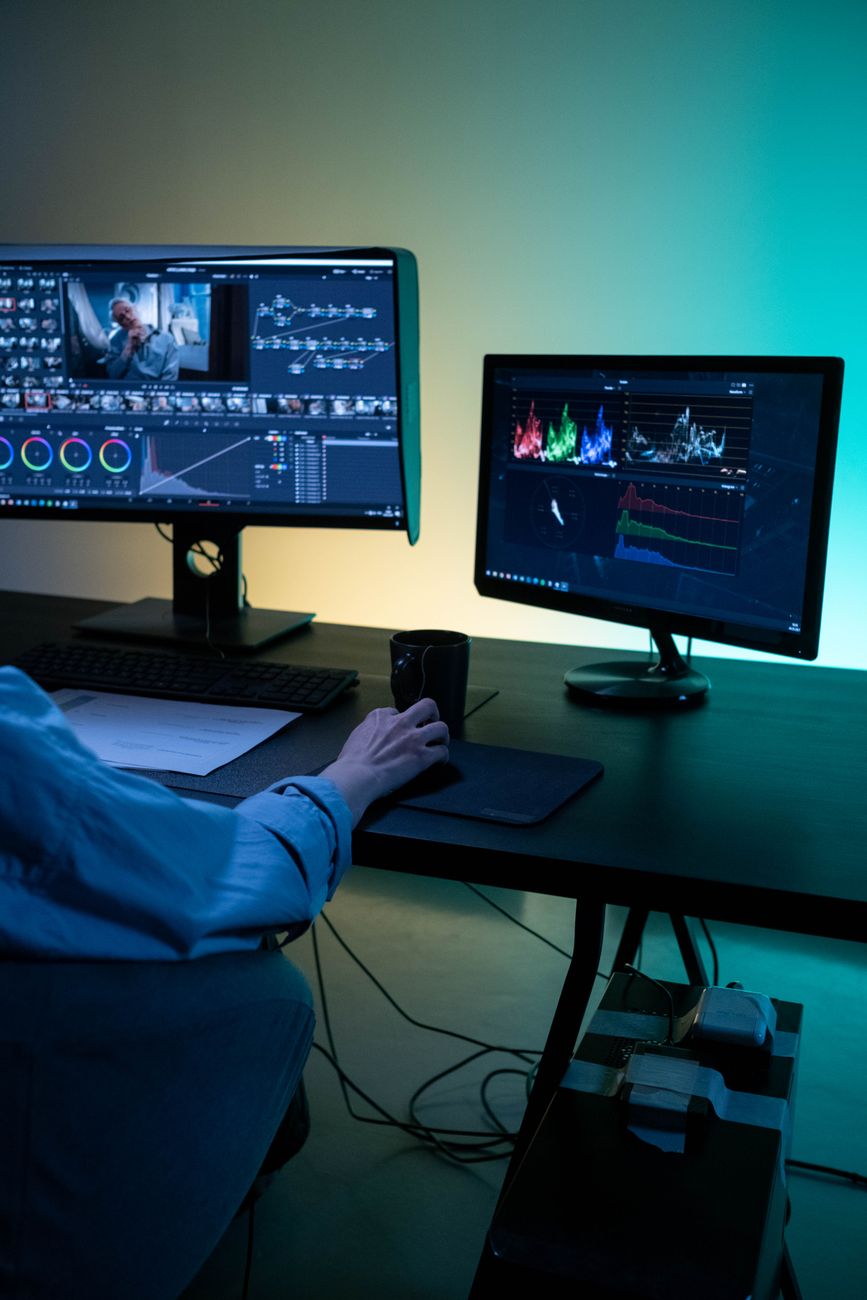 Editing bay desks with massive monitors and sound equipment